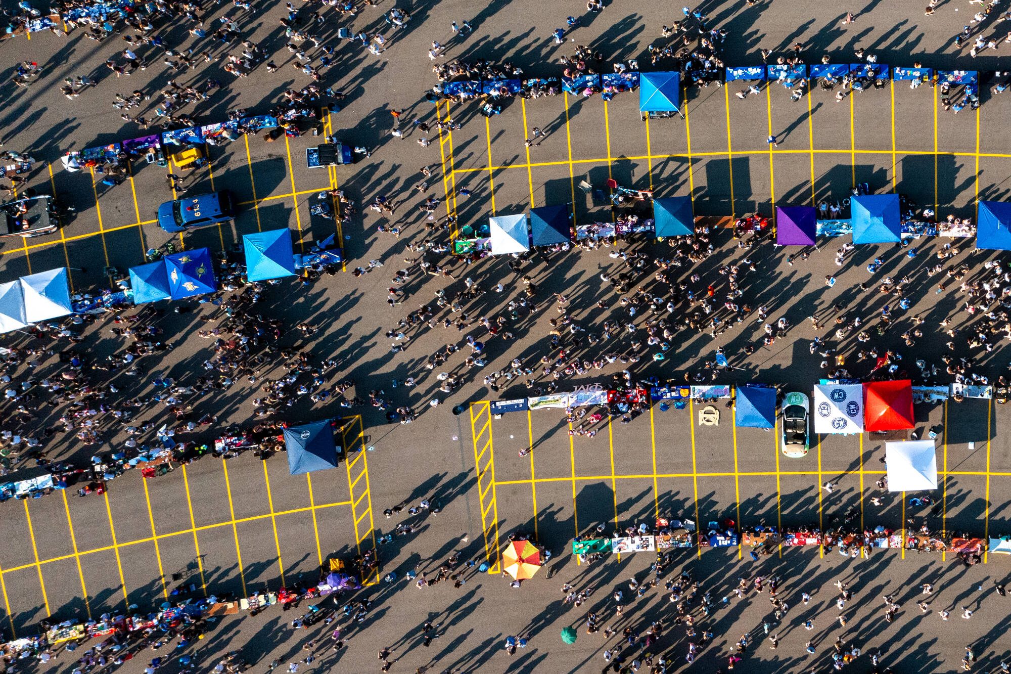Ariel shot of Campus Life Night at GVSU. Tents and tables lined up in rows in a parking lot with hundreds of people wandering through the aisles.